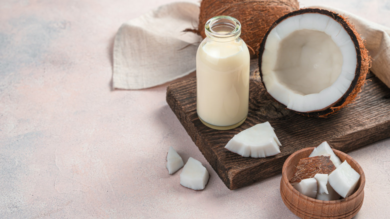 Fresh coconut on wood block with glass of milk
