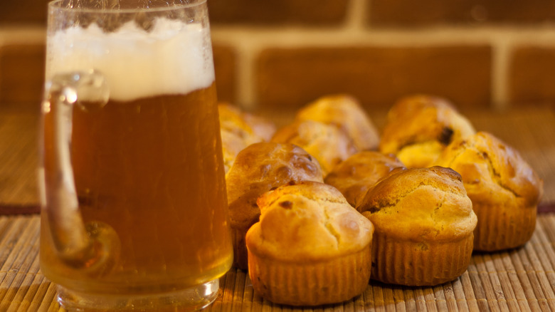 A stein of beer posed next to an assortment of mini muffins