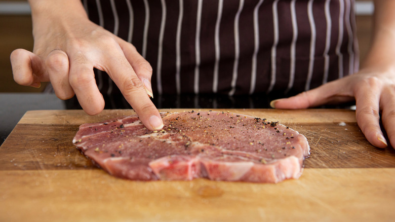 Chef touching raw meat