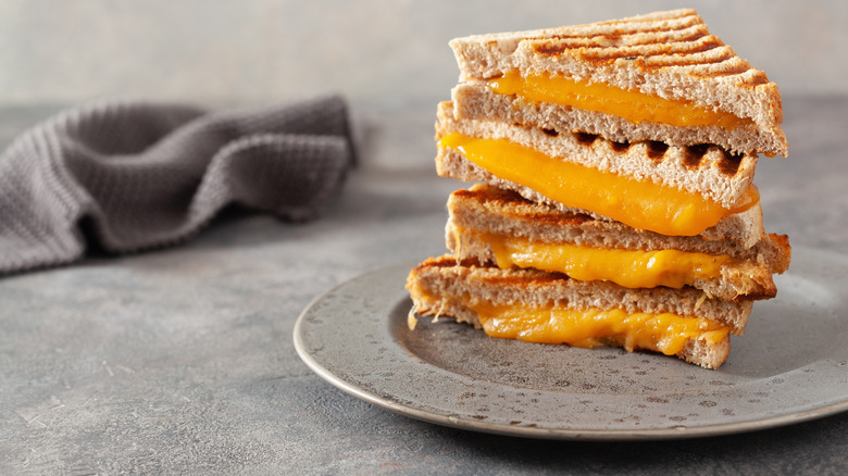 Grilled cheeses stacked on plate