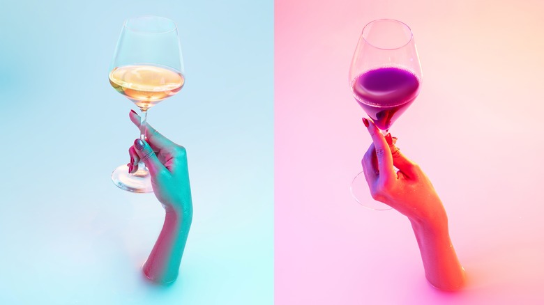Two different hands holding different wine glasses