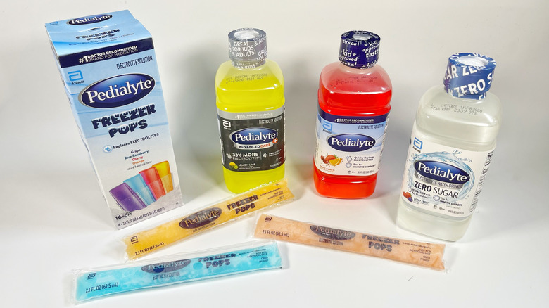 Several Pedialyte bottles and freezer pops on a white background