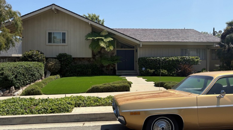 The outside of The Brady Bunch House with a yellow vintage car parked out front