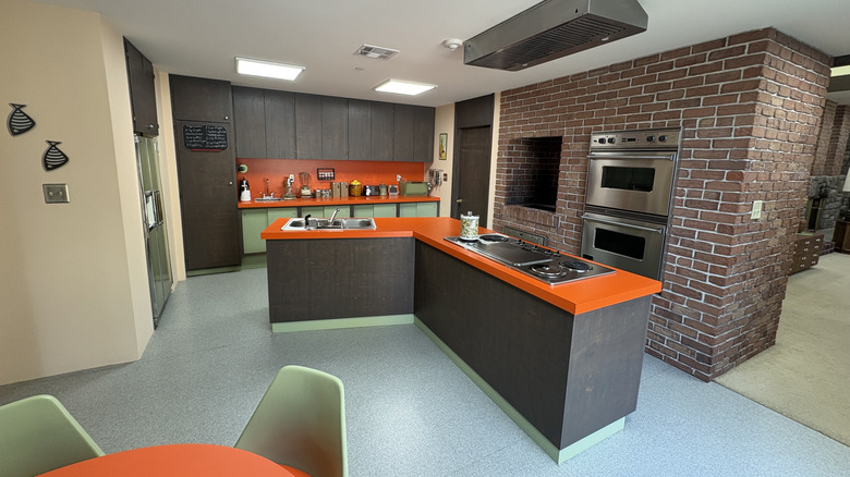 A wide shot of the Brady Bunch kitchen with the dining room table in the foreground