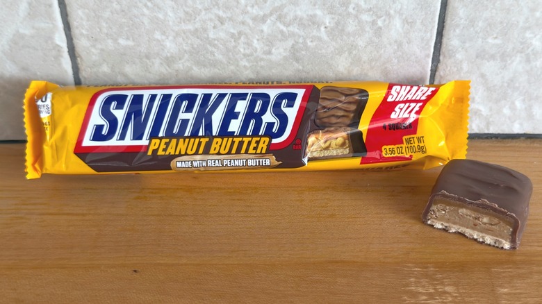 Peanut Butter Snickers bar with piece cut in half