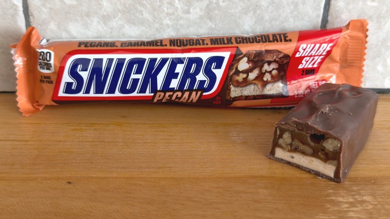 Pecan Snickers bar with piece cut in half