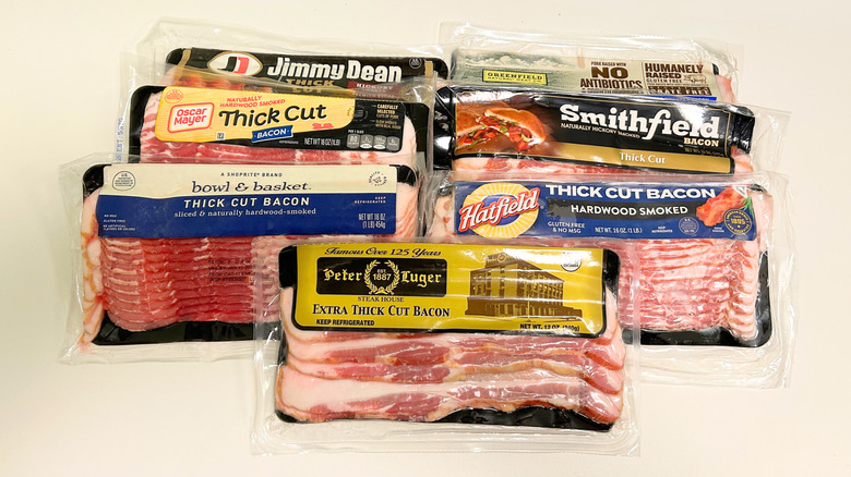 Seven thick cut bacon brands arranged together on a white background