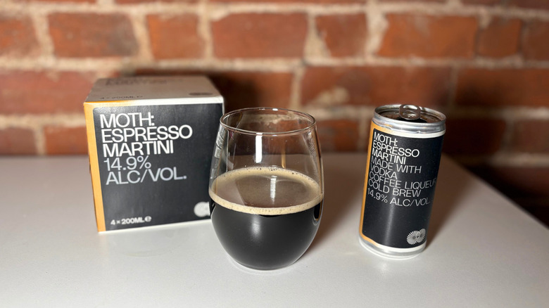 A package of MOTH next to a glass of espresso martini and a can of the drink against a brick backdrop