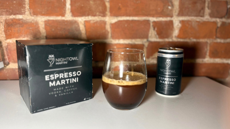 A package of Nightowl next to a glass of espresso martini and a can of the drink against a brick backdrop