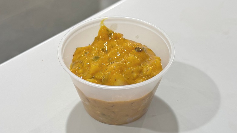 Plastic cup of chopped onions mixed with various condiments