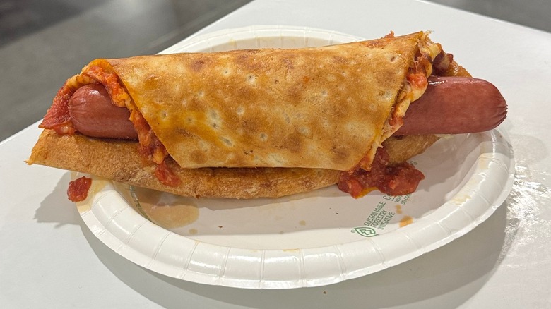 Costco hot dog rolled into a piece of pizza