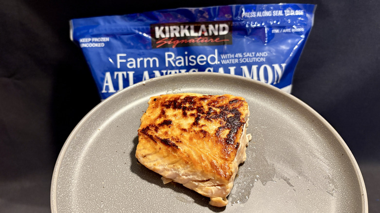 piece of cooked salmon on plate in front of package