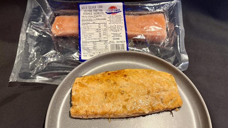 piece of cooked salmon on plate in front of package