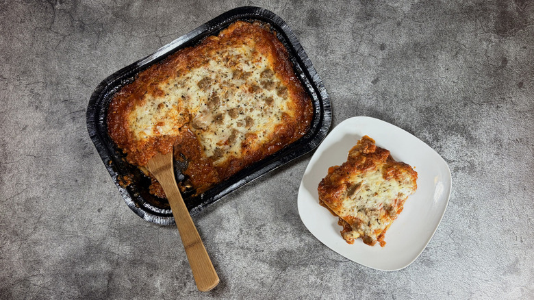 pan and plate of meat lasagna on table