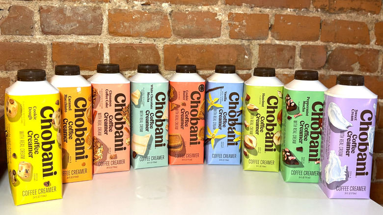 A line of Chobani coffee creamers against a brick backdrop