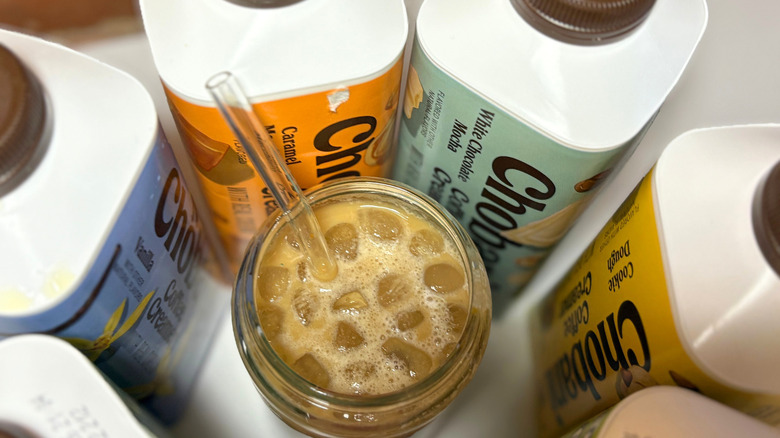 A circle of Chobani bottles with a glass cup of coffee in the middle