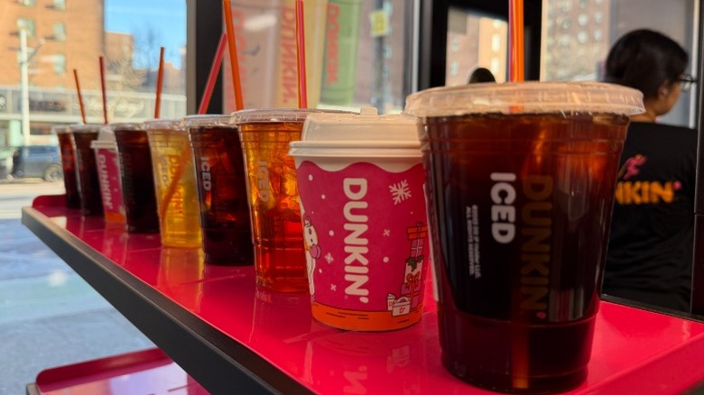 Nine Dunkin' drinks lined up on an order window
