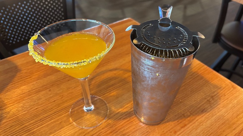 Applebee's Grey Goose Cocktail with sprinkle rim next to shaker on wooden table