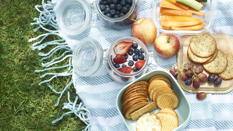 An overhead view of a picnic blanket covered in fresh food