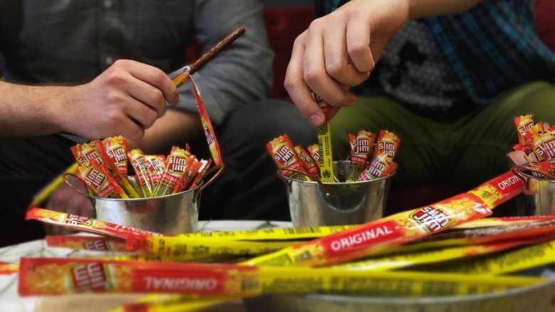 two people with buckets of Slim Jims