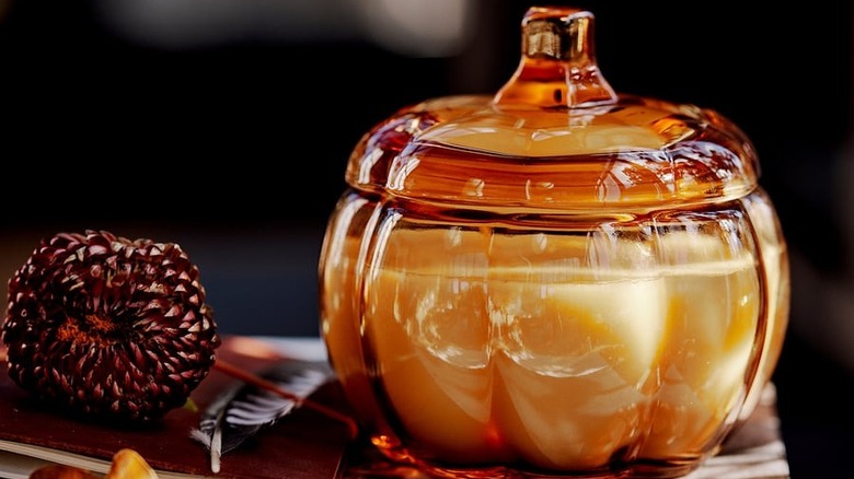 IKEA Höstagille spiced pumpkin scented candle in brown-colored glass on a stack of magazines
