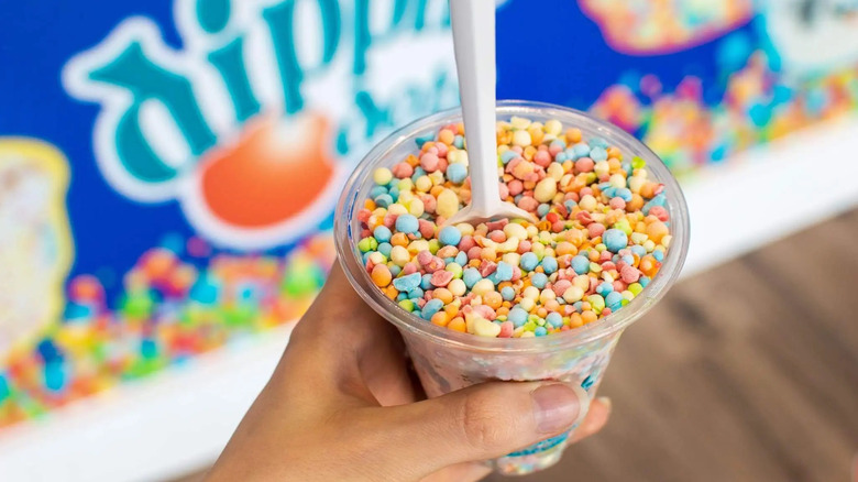 hand holding a cup of the Dippin' Dots with spoon