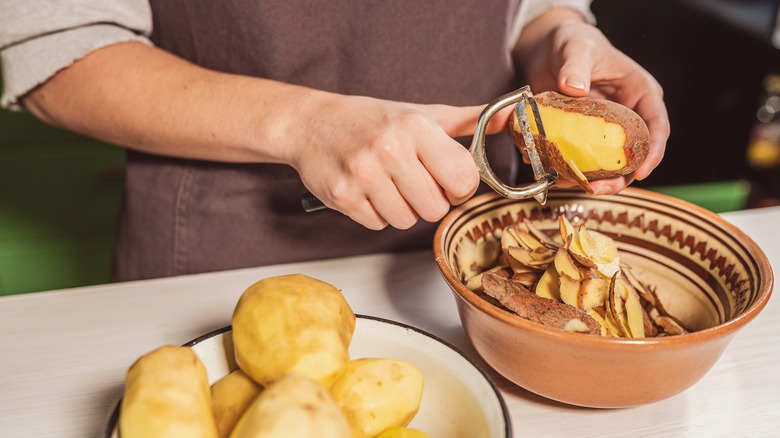 Peeling potato skin with peeler