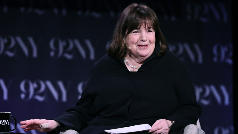 Close up of Ina Garten wearing all black against a dark background.