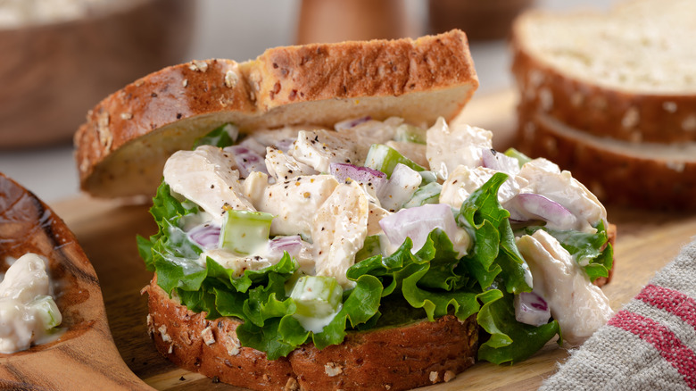 Chicken salad on a sandwich set on a cutting board