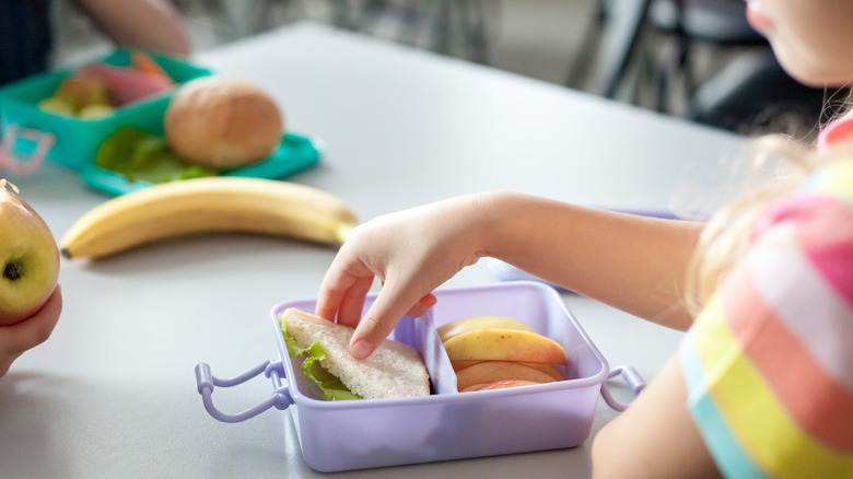 school children eating from lunchboxes