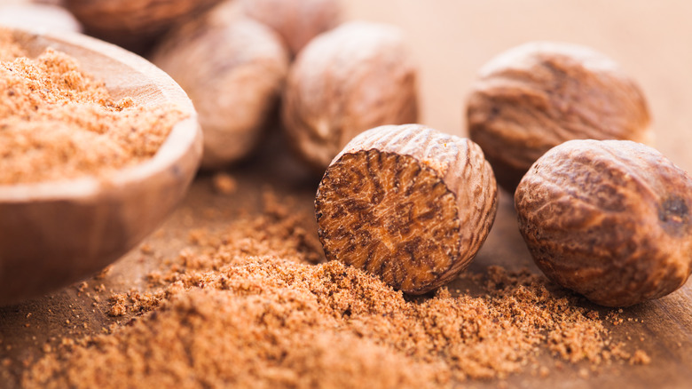 Whole and ground nutmeg on a board