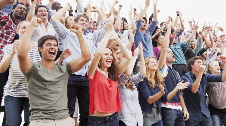 A crowd cheering at something off-camera