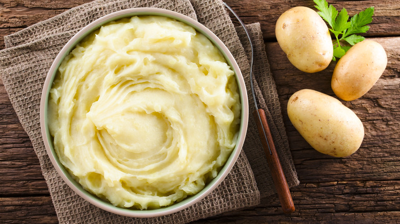 bowl of creamy mashed potatoes with whole potatoes