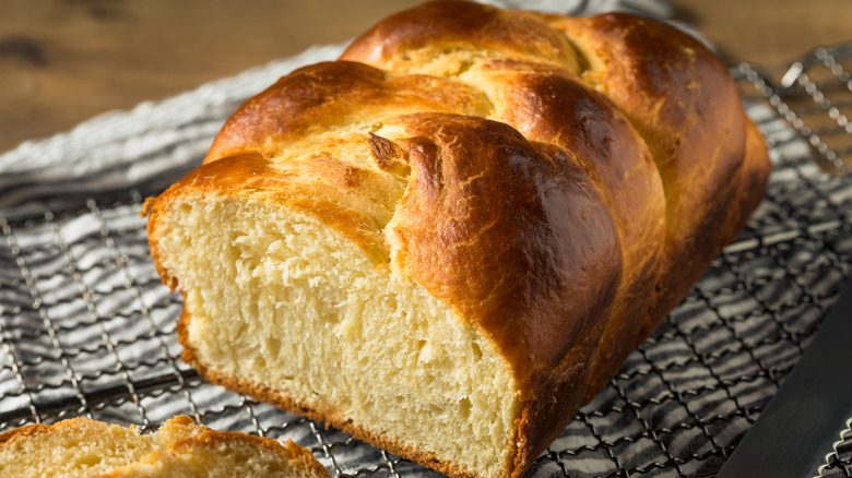 a loaf of brioche bread sits on a baking rack