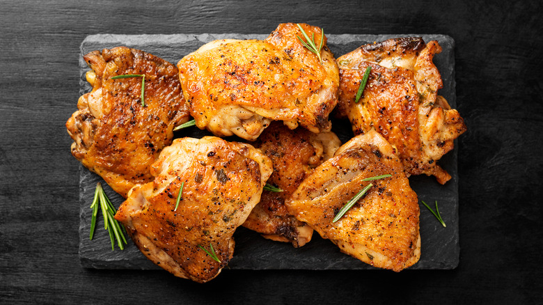 Chicken on black background with rosemary