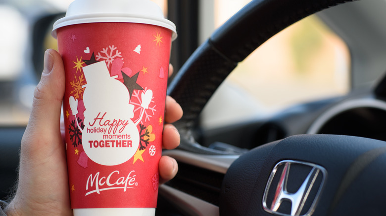 person holding McDonald's themed Christmas cup