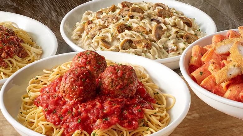 Different pasta dishes on wooden tabletop