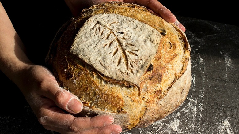 Artisan sourdough loaf and hands 