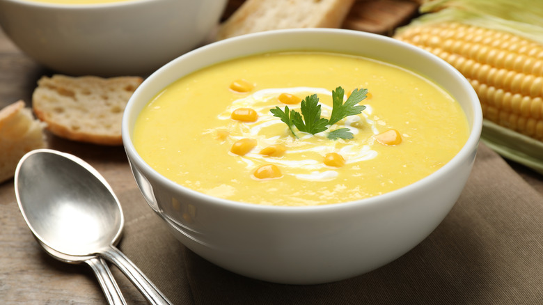corn chowder in bowl with corn and bread