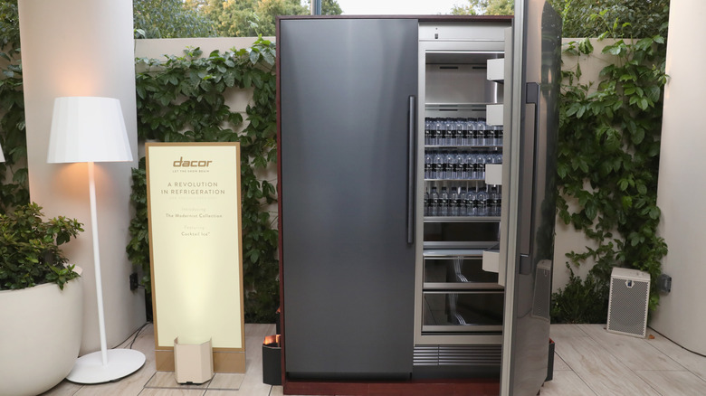 A Dacor refrigerator with an open door in a showroom