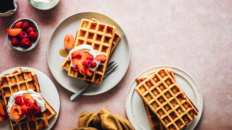 Plates of waffles with fruit