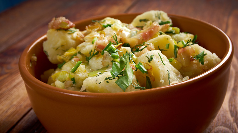 bowl of potato salad with caramelized onion and herbs