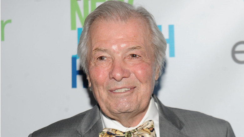 Jacques Pépin wearing a grey suit and designed bowtie at a red carpet event