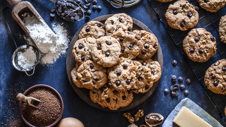 Pile of chocolate chip cookies around the ingredients to make them