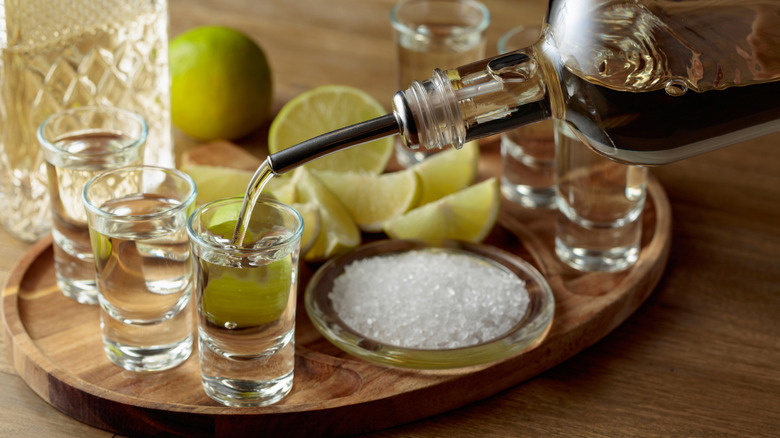 Tequila and limes in shot glasses