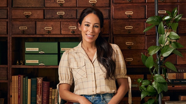 Joanna Gaines posing in front of catalogue/book shelving