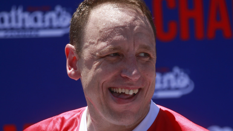 Joey Chestnut holding hot dogs at Nathan's hot dog contest