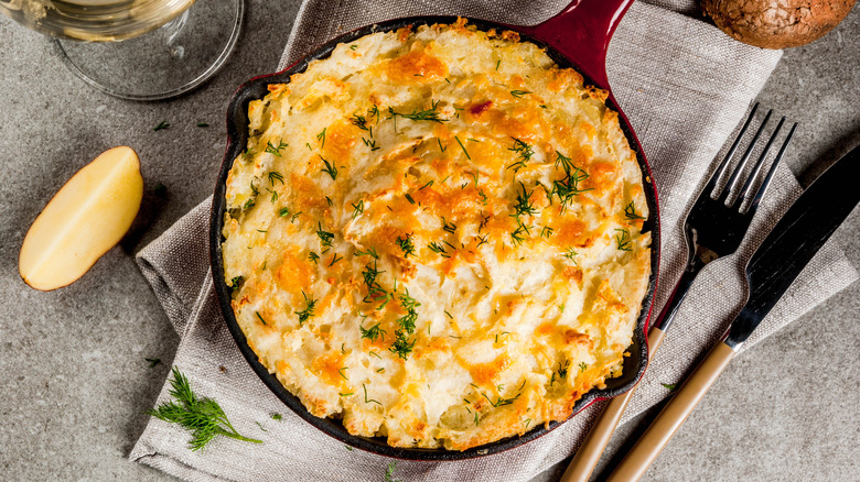 Shepherd's pie in a skillet next to a fork and knife
