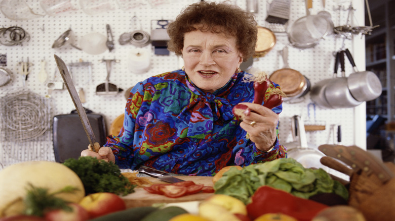 Close-up of Julia Child holding a knife and some peppers