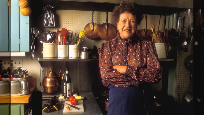 Julia Child standing in front of a stove